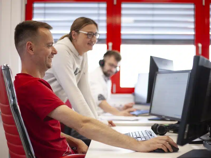 Drei Personen arbeiten gemeinsam im Büro am Computer