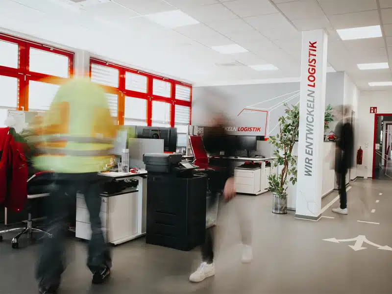 Modernes Logistikbüro mit Mitarbeitern in Bewegung